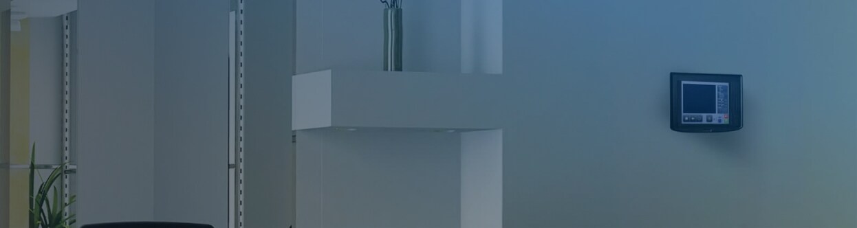 A PROFILE fire detection unit mounted on an office wall, overlaid with a blue gradient