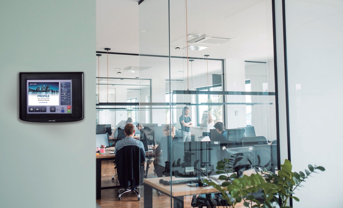 A PROFILE fire detection panel from Zettler mounted on a wall outside an occupied office suite